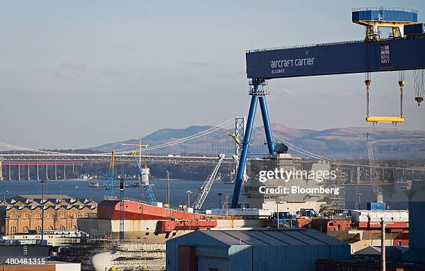 Dockyard crane stands over the Royal Navy's new Queen Elizabeth class aircraft carrier, manufactured by BAE Systems, as it stands during assembly at...