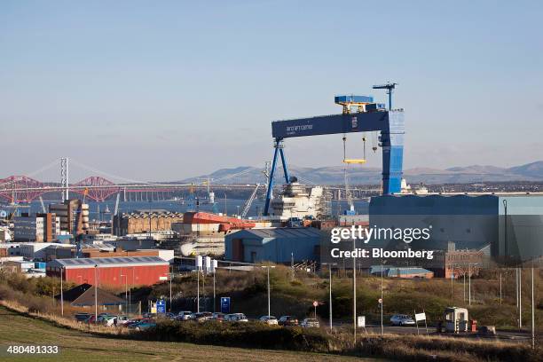 Dockyard crane stands over the Royal Navy's new Queen Elizabeth class aircraft carrier, manufactured by BAE Systems, as it stands during assembly at...