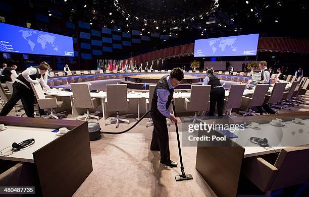 Waiters prepare the plenary table during a break at the 2014 Nuclear Security Summit on March 25, 2014 in The Hague, Netherlands. Leaders from around...