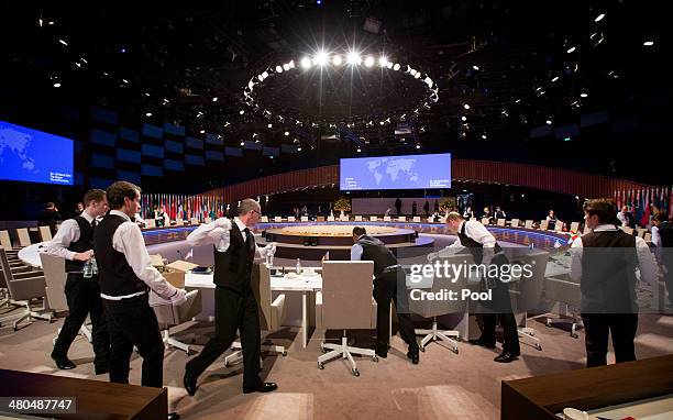 Waiters prepare the plenary table during a break at the 2014 Nuclear Security Summit on March 25, 2014 in The Hague, Netherlands. Leaders from around...