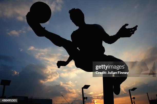 The Dennis Bergkamp statue is silhouetted against the evening sky ahead of the Barclays Premier League match between Arsenal and Swansea City at...