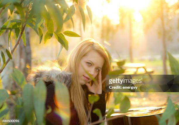 young woman in the park - sad musician stock pictures, royalty-free photos & images