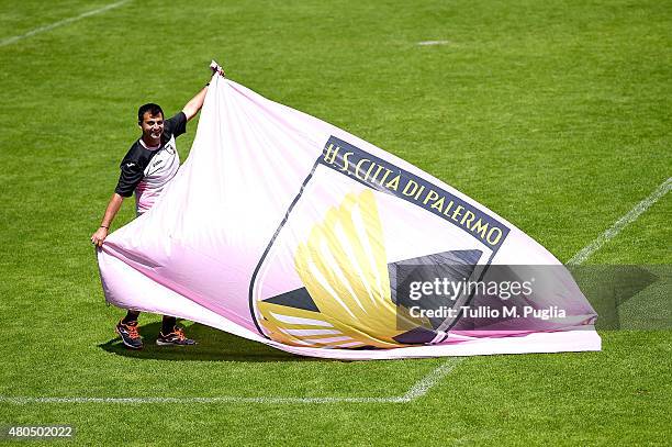 Kit Manager Pasquale Castellana prepares a flag of US Citta di Palermo after a Palermo training session on July 12, 2015 in Bad Kleinkirchheim,...
