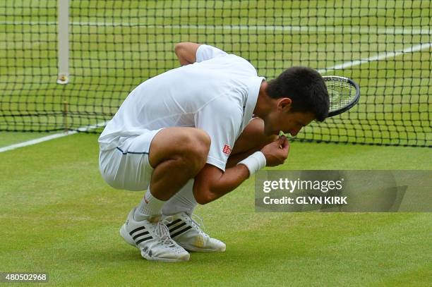 Serbia's Novak Djokovic celebrates beating Switzerland's Roger Federer by eating a blade of grass during their men's singles final match on Centre...