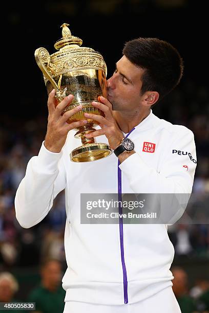 Novak Djokovic of Serbia celebrates with the trophy after winning the Final Of The Gentlemen's Singles against Roger Federer of Switzerland on day...