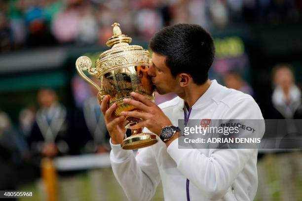 Serbia's Novak Djokovic kisses the winner's trophy after beating Switzerland's Roger Federer in the men's singles final match, during the...