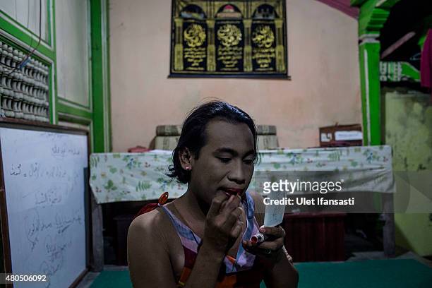 Inez, a member of a Pesantren boarding school, Al-Fatah, for transgender people known as 'waria' applies make-up to her face during Ramadan on July...