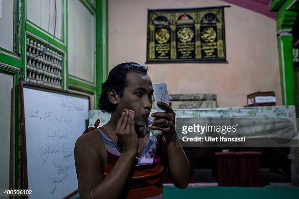 Inez, a member of a Pesantren boarding school, Al-Fatah, for transgender people known as 'waria' applies make-up to her face during Ramadan on July...