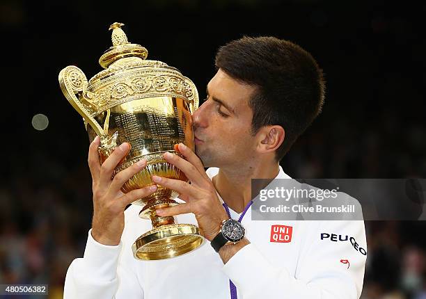 Novak Djokovic of Serbia celebrates with the trophy after winning the Final Of The Gentlemen's Singles against Roger Federer of Switzerland on day...