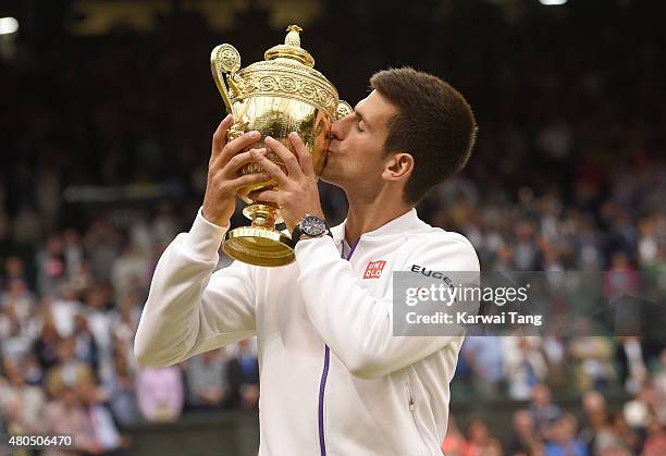 Novak Djokovic of Serbia celebrates with the trophy after winning the Final Of The Gentlemen's Singles against Roger Federer of Switzerland on day 13...