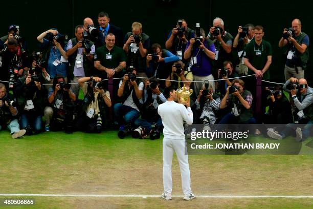 Serbia's Novak Djokovic kisses the winner's trophy after beating Switzerland's Roger Federer in the men's singles final match, during the...