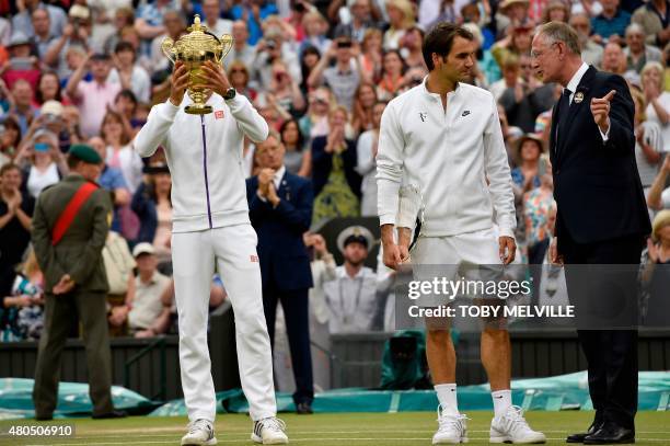 Serbia's Novak Djokovic holds the winner's trophy as he stands alongside Switzerland's Roger Federer after winning the men's singles final match,...