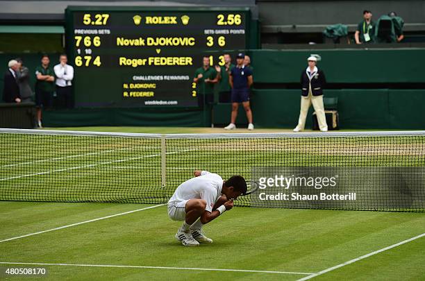Novak Djokovic of Serbia eats the centre court grass after winning the Final Of The Gentlemen's Singles against Roger Federer of Switzerland on day...