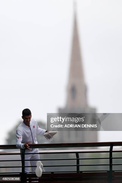 Serbia's Novak Djokovic stands on a balcony and throws his shoes into the crowd after beating Switzerland's Roger Federer in the men's singles final...