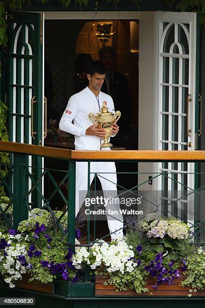 Novak Djokovic of Serbia celebrates with the trophy on the clubhouse balcony after winning the Final Of The Gentlemen's Singles against Roger Federer...