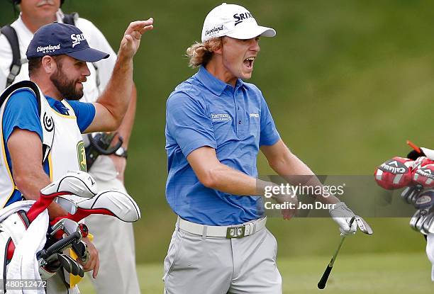 Will Wilcox celebrates with his caddie Kevin Ensor after hitting an eagle on the first hole during the final round of the John Deere Classic held at...