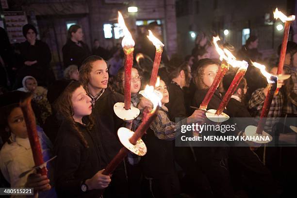 Ultra-Orthodox Jewish children hold torches as they welcome Yakov Israel Paz, an Ultra-Orthodox Jewish student who was released after spending the...