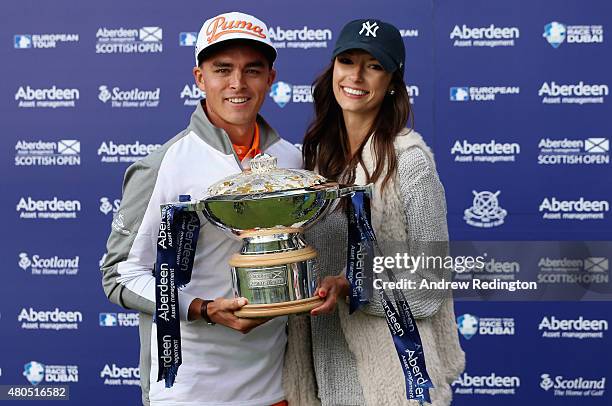 Rickie Fowler of the United States celebrates with the trophy alongside his girlfriend, Alexis Randock, after winning the Aberdeen Asset Management...