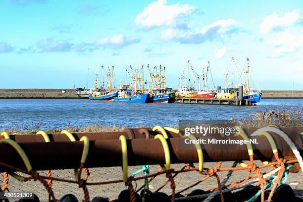 rusty spar and fishing nets with ships in the background - shrimp boat stockfoto's en -beelden