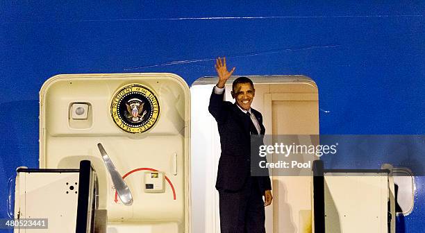 President Barack Obama waves as he walks up the stairs of Air Force One before leaving Amsterdam Airport Schiphol March 25, 2014 in Amsterdam,...