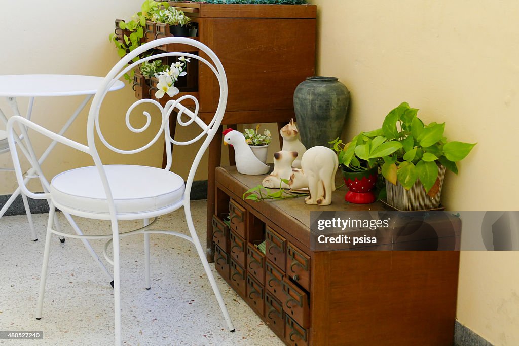 White chair, desk and plant decorating on wooden desk drawer