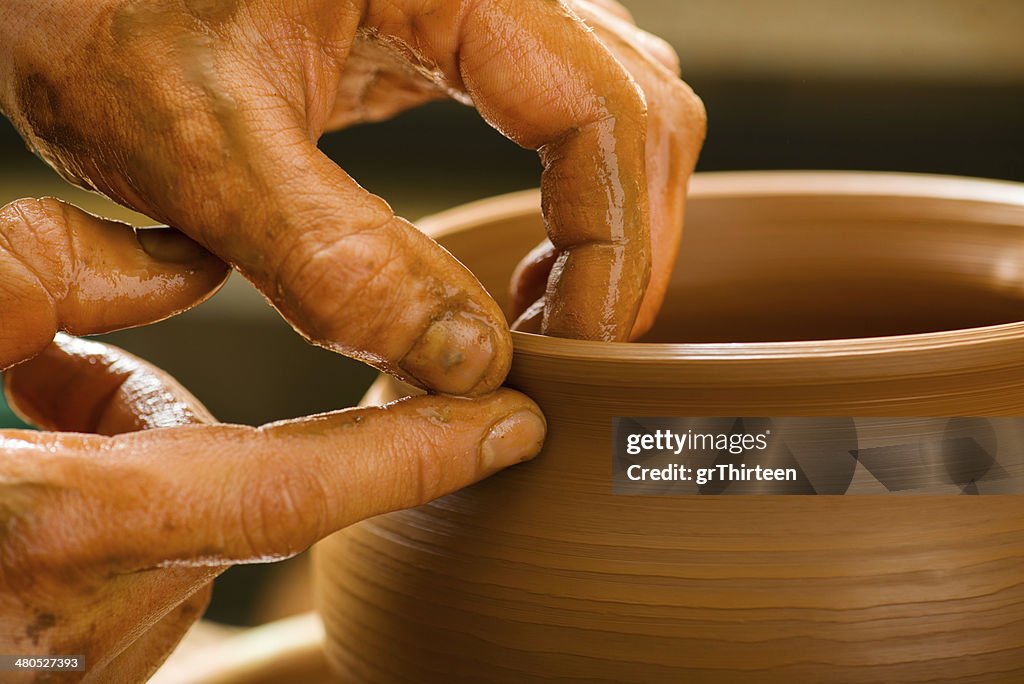 Hände eines potter, die eine erdige Einmachglas