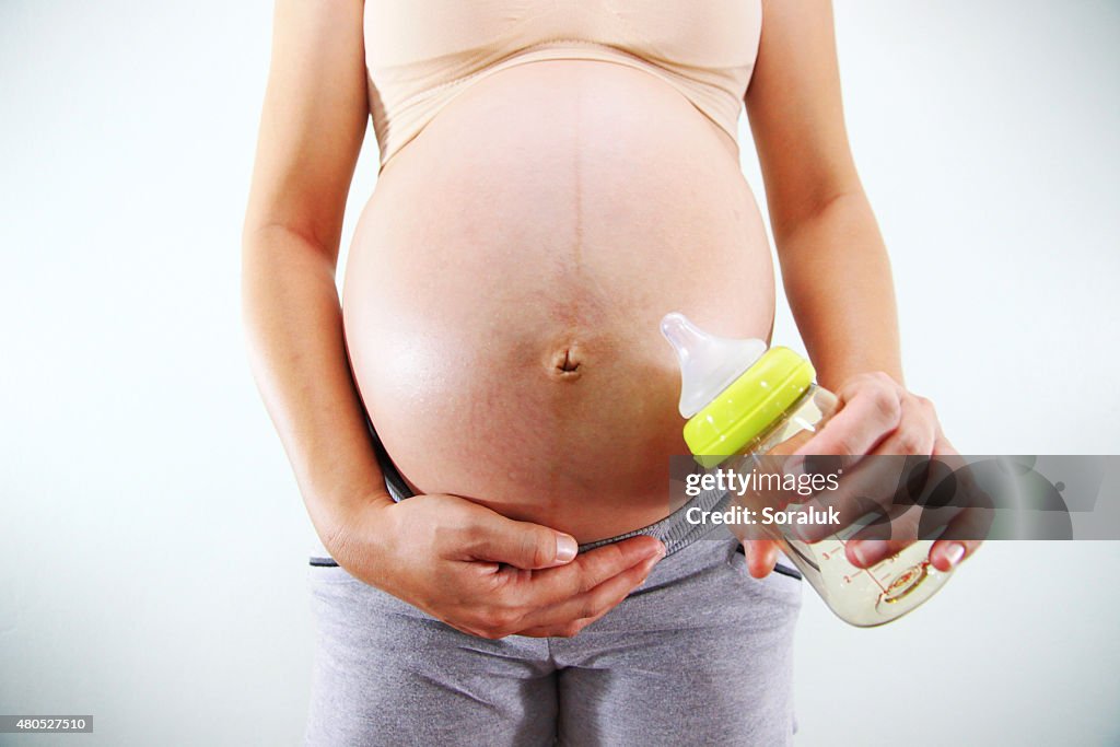 妊娠中の女性、ボトルのミルクます。