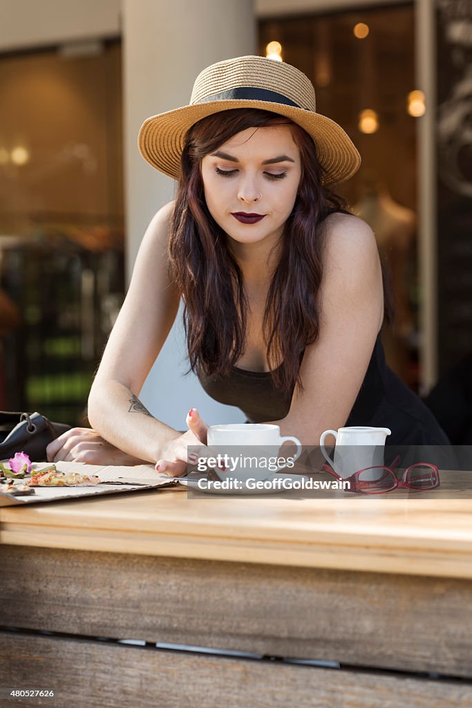 Young beautiful traveler enjoying a coffee at street cafe