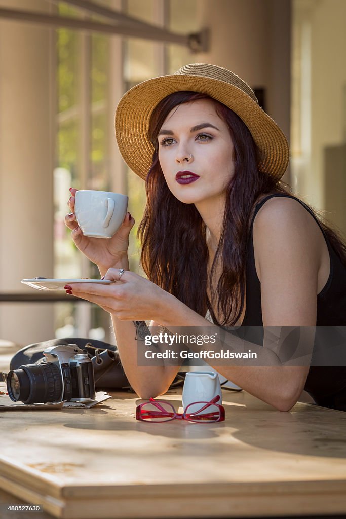 Young beautiful traveler enjoying a coffee at street cafe