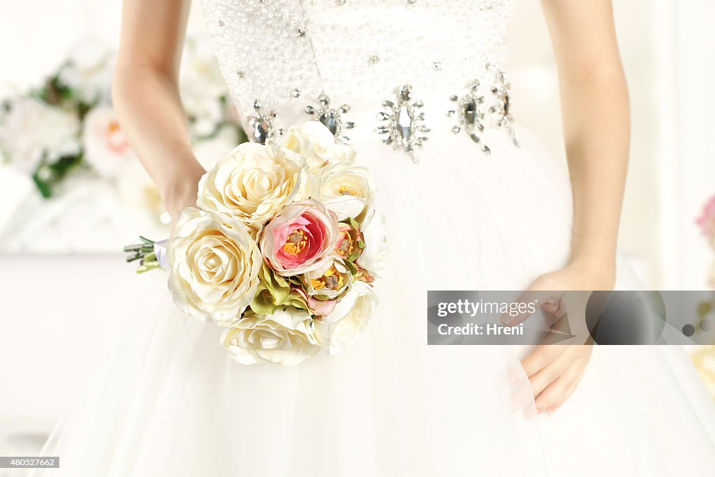 Hands of a bride holding a beautiful bouquet