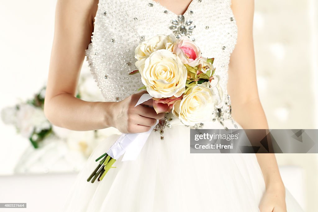 Hands of a bride holding a beautiful bouquet