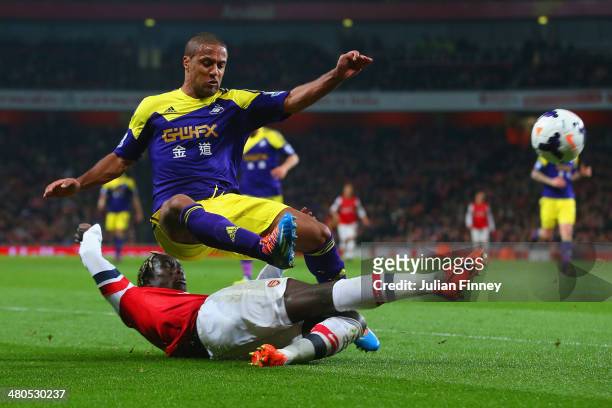 Bacary Sagna of Arsenal tackles Wayne Routledge of Swansea City during the Barclays Premier League match between Arsenal and Swansea City at Emirates...