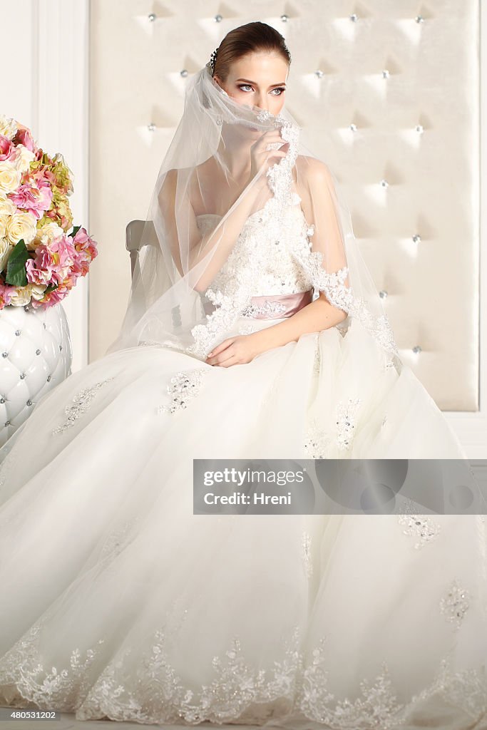 Gorgeous bride in a white room, posing