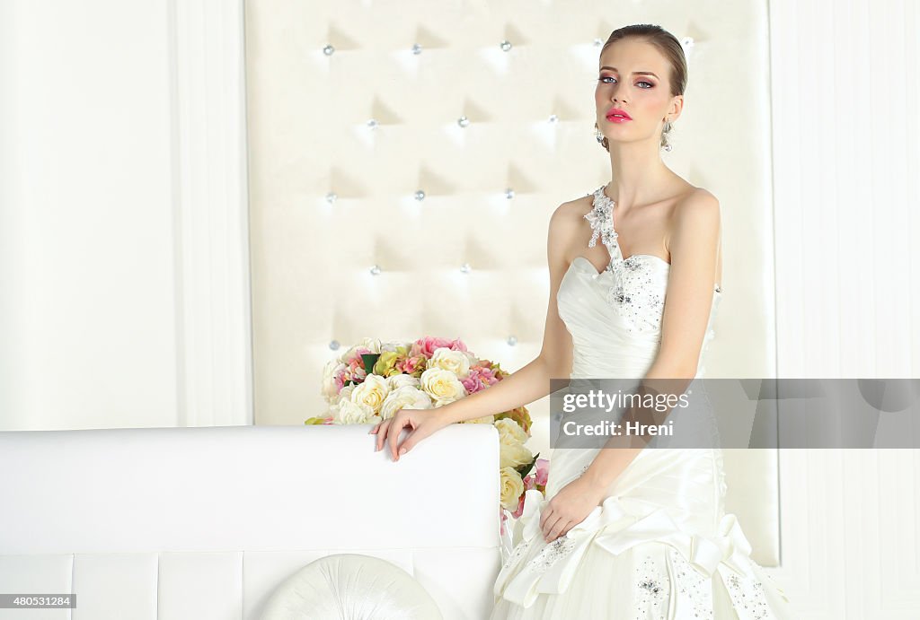 Schöne Braut in einem weißen Raum, Posieren