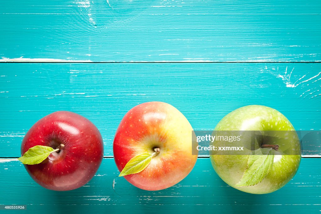 Bunte Äpfel auf Türkis Tisch