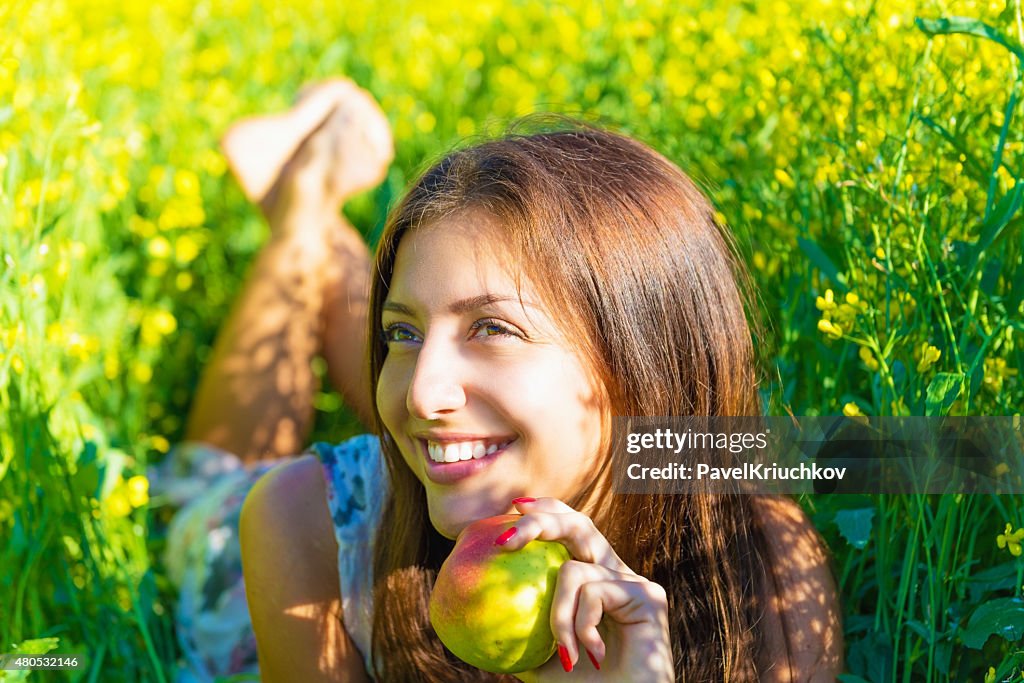 Porträt der schönen lächelnden Frau mit einem Apfel