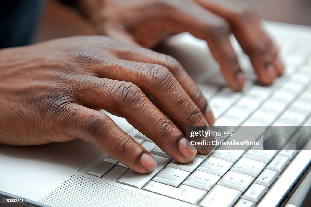 Primer plano de las manos en un teclado de África