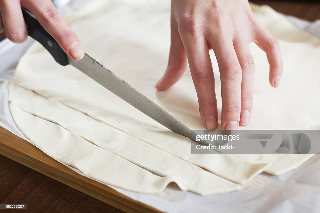 Hands cutting store-bought dough