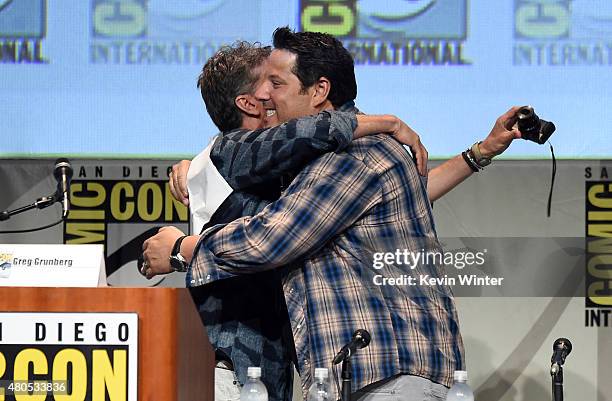 Actor Greg Grunberg and writer/producer Tim Kring embrace onstage at the "Heroes Reborn" exclusive extended trailer and panel during Comic-Con...
