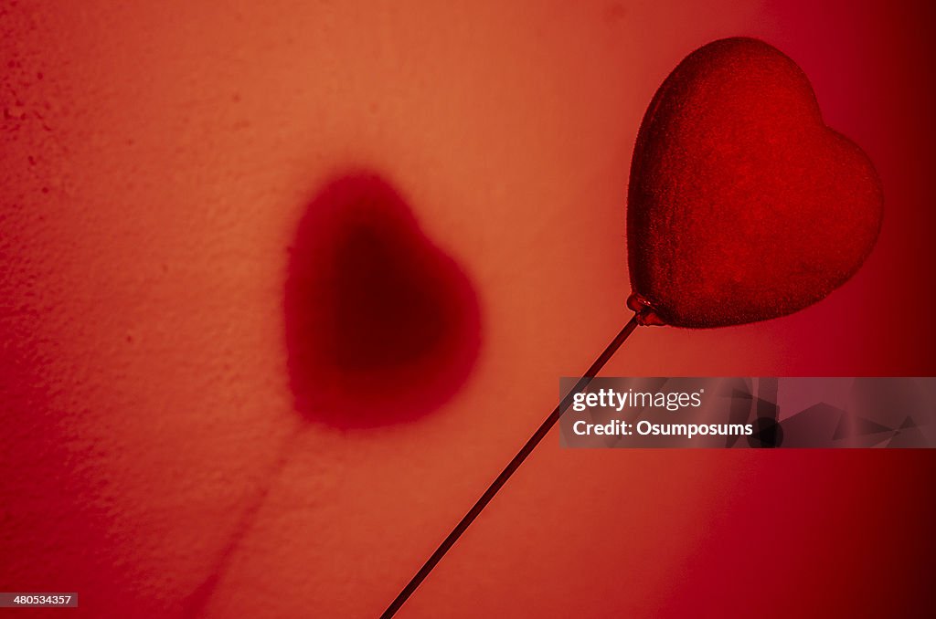Beautiful red heart play game with a shadow on wall