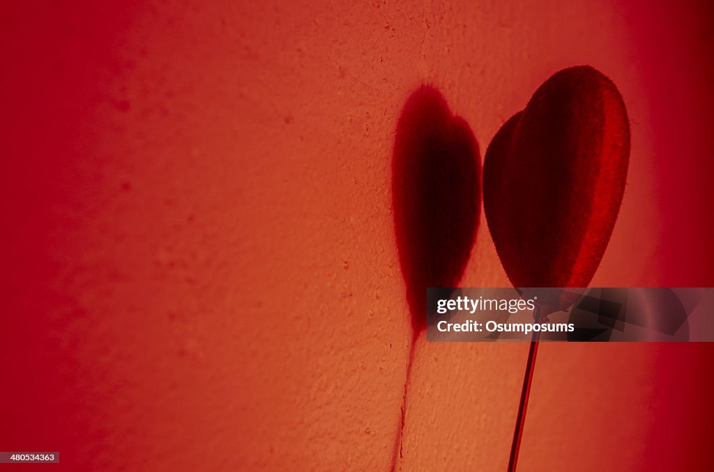 Beautiful red heart play game with a shadow on wall