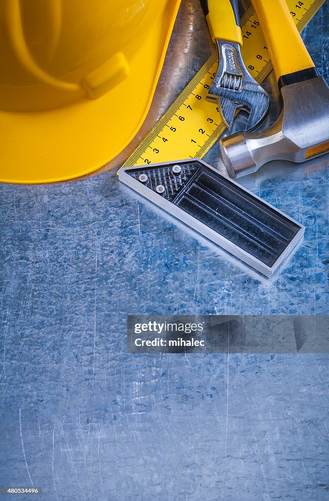 Hard hat claw hammer square ruler and adjustable spanner on