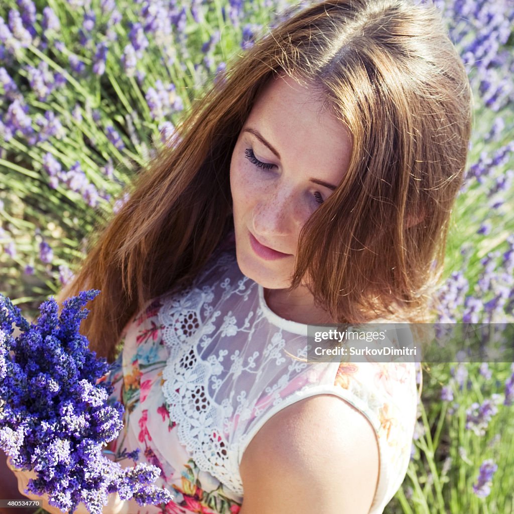 Mujer joven en un prado con flores de lavanda