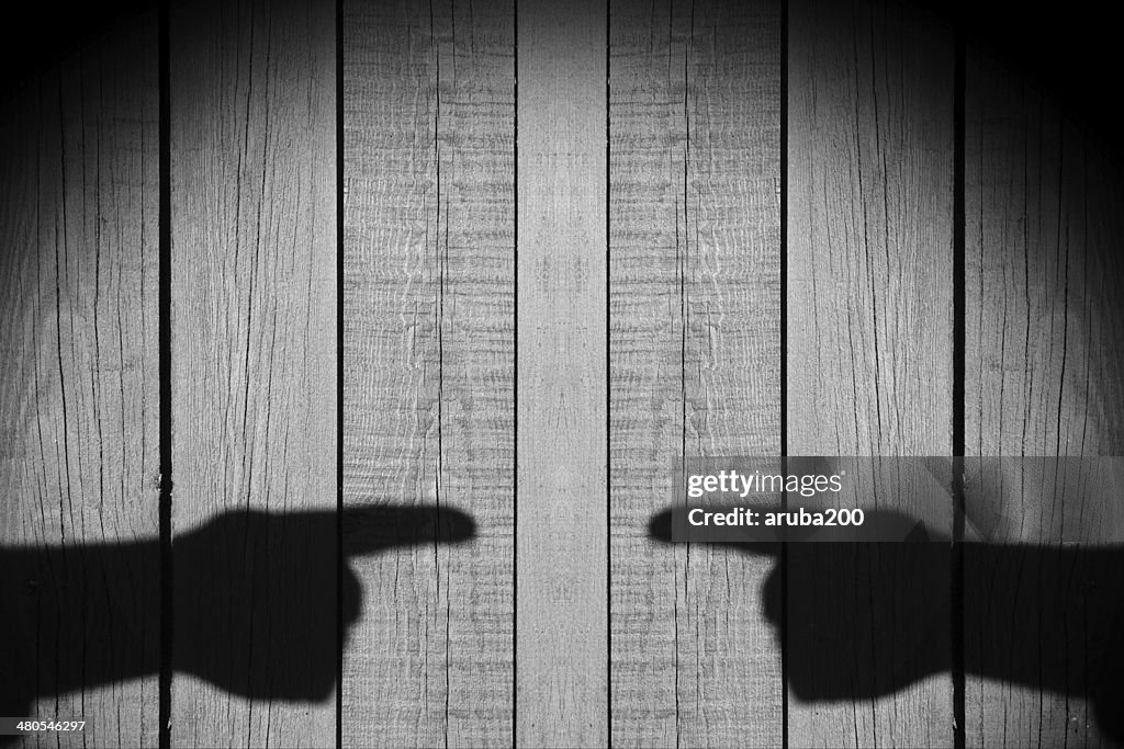 Two Male Hands with index finger on a wooden background