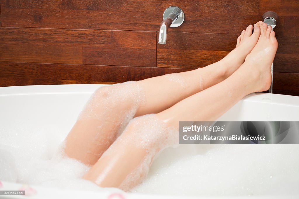 Legs of young woman in bathtub