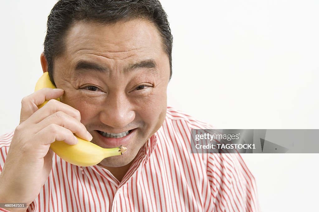 Man making a phone call using banana