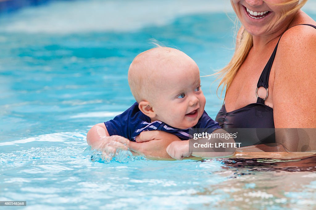 Baby learning to swim with his mother