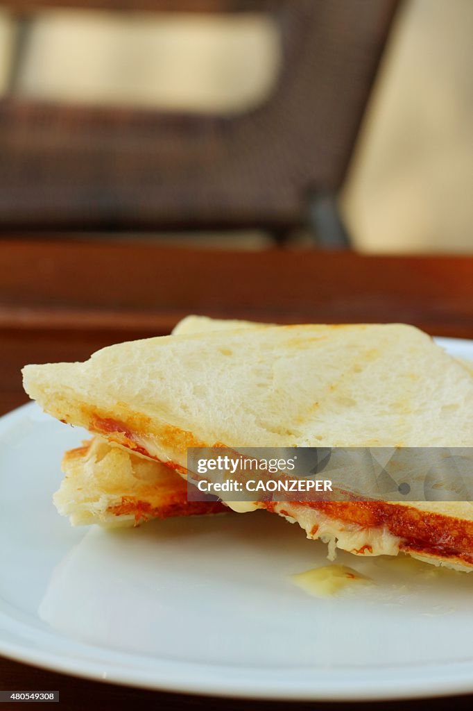 Ham and cheese sandwich on a white plate.