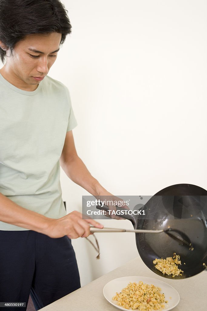 Man transfering fried rice to plate