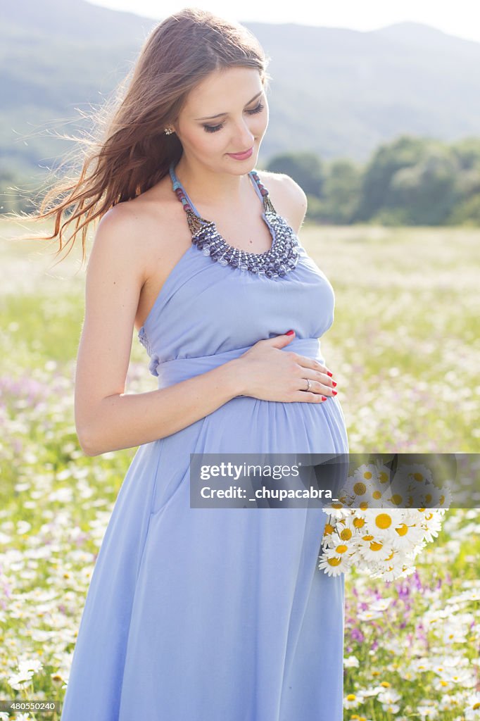 Pregnant woman with bouquet of daisy flowers